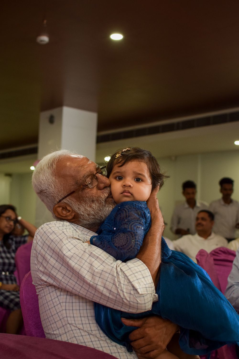A grandfather hugging his granddaughter outside their home