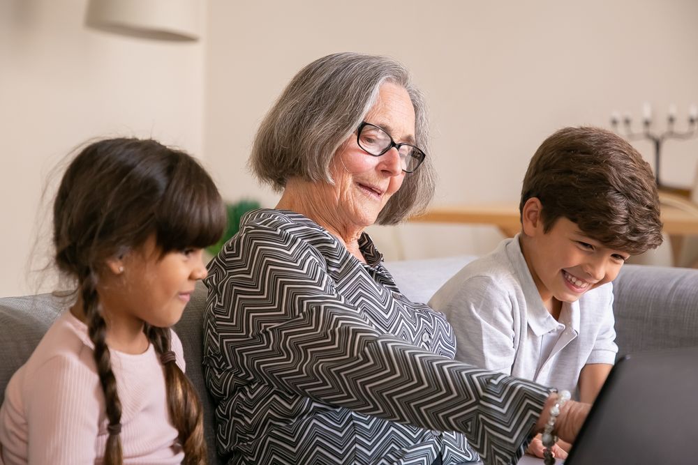 A grandmother laughing with her grandchildren on the couch